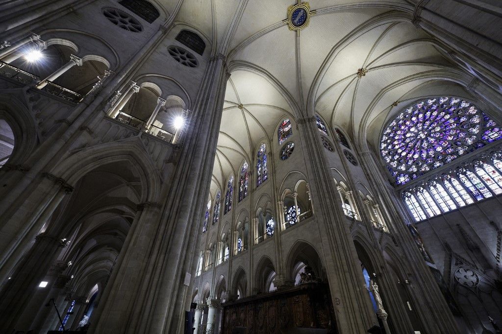 French President Emmanuel Macron (C-L) applauds with attendees, including workers of reconstruction of Notre-Dame de Paris cathedral, during his visit to the cathedral in Paris, on November 29, 2024. The Notre-Dame Cathedral is set to re-open early December 2024, with a planned weekend of ceremonies on December 7 and 8, 2024, five years after the 2019 fire which ravaged the world heritage landmark and toppled its spire. (Photo by Sarah Meyssonnier / POOL / AFP)