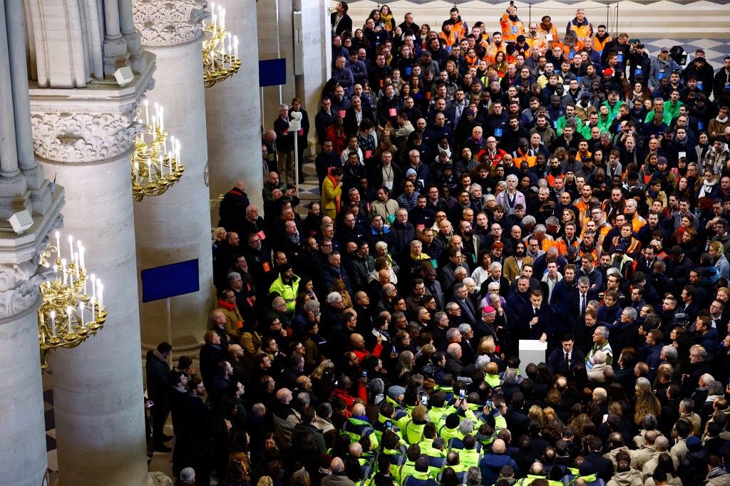 French President Emmanuel Macron (C-L) applauds with attendees, including workers of reconstruction of Notre-Dame de Paris cathedral, during his visit to the cathedral in Paris, on November 29, 2024. The Notre-Dame Cathedral is set to re-open early December 2024, with a planned weekend of ceremonies on December 7 and 8, 2024, five years after the 2019 fire which ravaged the world heritage landmark and toppled its spire. (Photo by Sarah Meyssonnier / POOL / AFP)