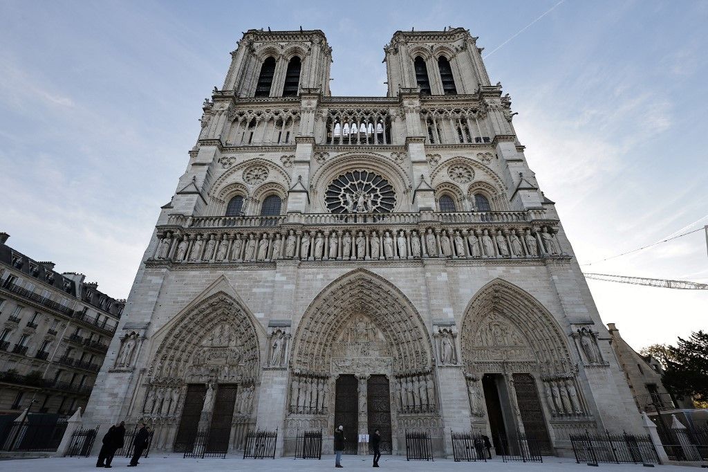 French President Emmanuel Macron (C-L) applauds with attendees, including workers of reconstruction of Notre-Dame de Paris cathedral, during his visit to the cathedral in Paris, on November 29, 2024. The Notre-Dame Cathedral is set to re-open early December 2024, with a planned weekend of ceremonies on December 7 and 8, 2024, five years after the 2019 fire which ravaged the world heritage landmark and toppled its spire. (Photo by Sarah Meyssonnier / POOL / AFP)