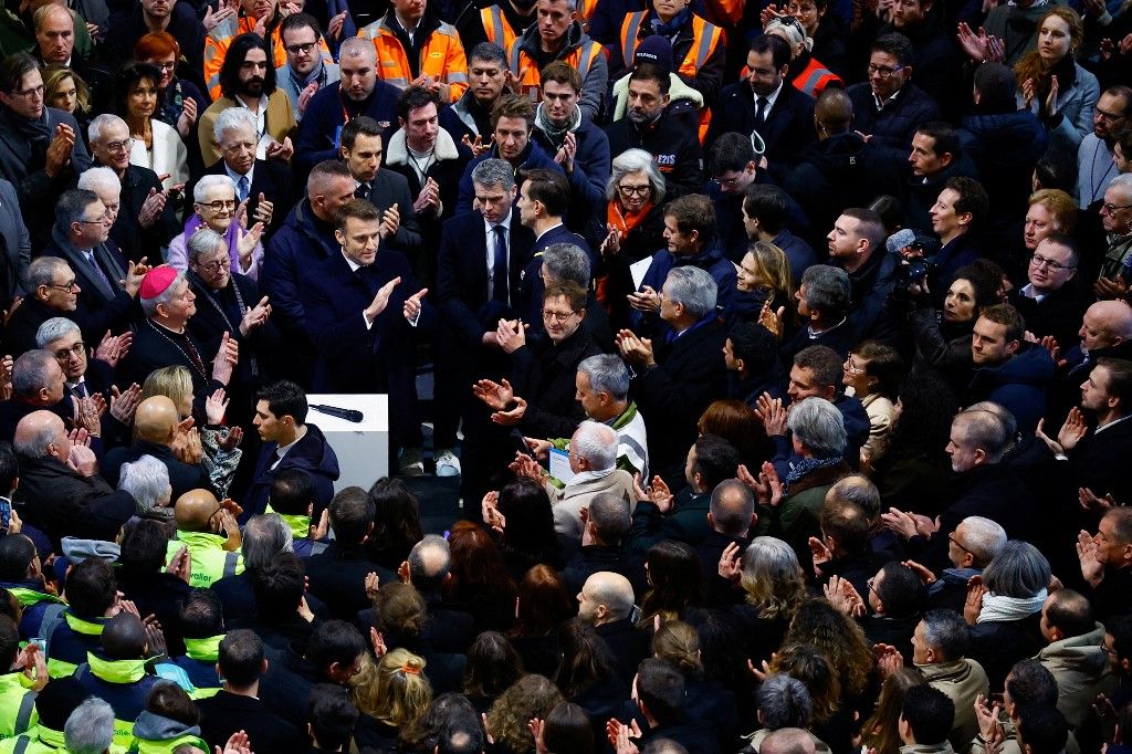 French President Emmanuel Macron (C-L) applauds with attendees, including workers of reconstruction of Notre-Dame de Paris cathedral, during his visit to the cathedral in Paris, on November 29, 2024. The Notre-Dame Cathedral is set to re-open early December 2024, with a planned weekend of ceremonies on December 7 and 8, 2024, five years after the 2019 fire which ravaged the world heritage landmark and toppled its spire. (Photo by Sarah Meyssonnier / POOL / AFP)