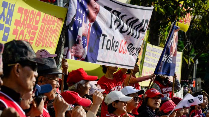 Supporters of former US President and Republican presidential candidate Donald Trump hold banners and chant slogans during a rally a block away from the US Embassy in Seoul on November 5, 2024. (Photo by Anthony WALLACE / AFP)