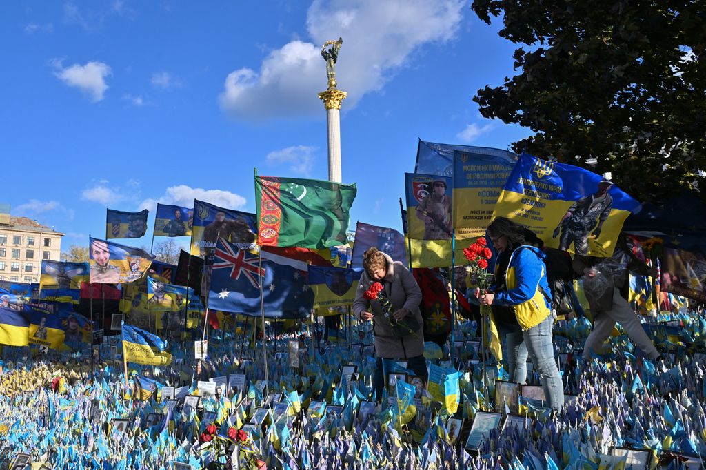 Women lay flowers in tribute to fallen Ukrainian soldiers at a makeshift memorial at Independence Square in Kyiv, on November 2, 2024, amid the Russian invasion in Ukraine. (Photo by Sergei SUPINSKY / AFP)