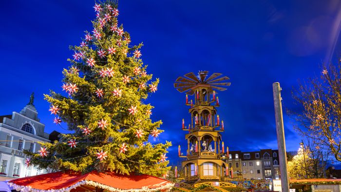 Cottbus Christmas market before opening20 November 2024, Brandenburg, Cottbus: A decorated, large Christmas tree and a pyramid stand together with closed stalls at the Cottbus Christmas market of 1000 stars in the evening. The Christmas market on the Altmarkt in Cottbus city center will open on 25.11.2024. Photo: Patrick Pleul/dpa/ZB (Photo by PATRICK PLEUL / DPA / dpa Picture-Alliance via AFP)