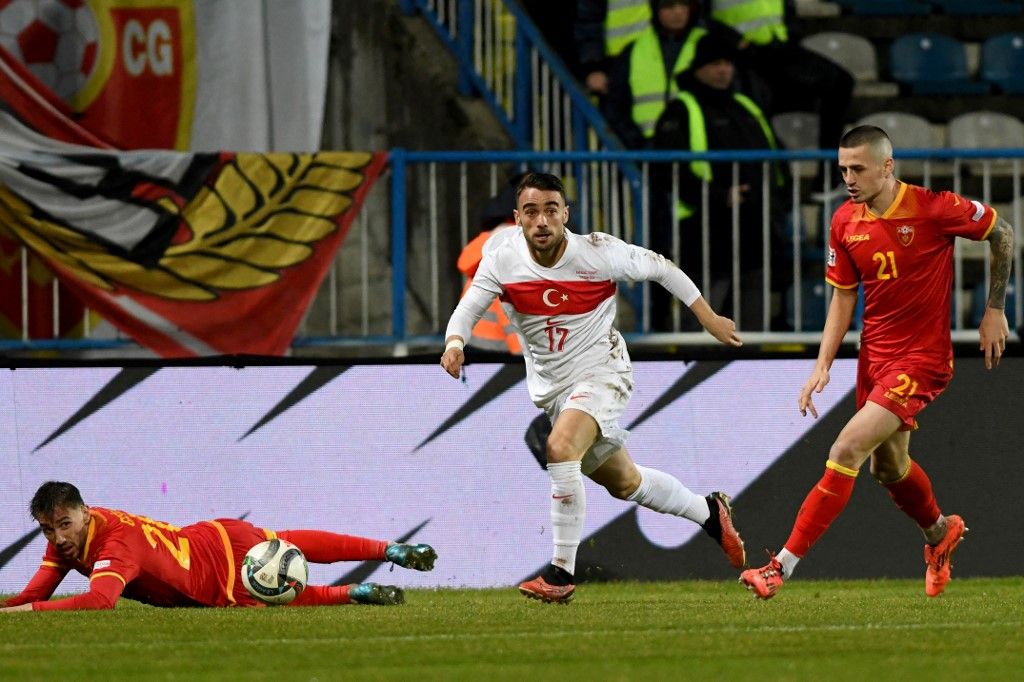 Turkey's forward #17 Yunus Akgun (C) runs past Montenegro's midfielder #20 Ognjen Gaevi? (L) and Montenegro's midfielder #21 Stefan Lon?ar (R) during the UEFA Nations League League B group 4 football match between Montenegro and Turkey at the City Stadium in Niksic on November 19, 2024. (Photo by SAVO PRELEVIC / AFP)