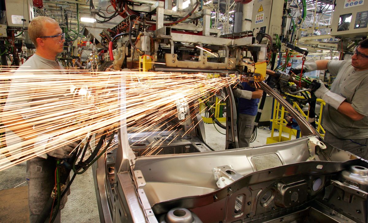 Romanians work at a Renault-Dacia model called "Logan" at the Dacia factory in Mioveni, 130 km (81 m..
