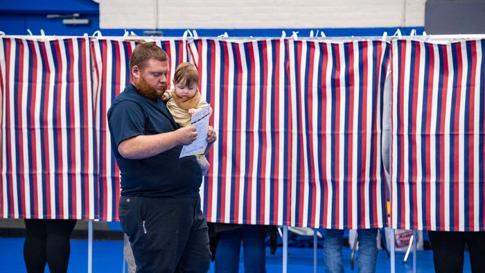 A person carries a baby with a filled out ballot after voting at the Green Street Community Center in Concord, New Hampshire, on November 5, 2024. (Photo by Joseph Prezioso / AFP)