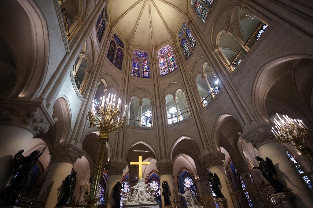 French President Emmanuel Macron (C-L) applauds with attendees, including workers of reconstruction of Notre-Dame de Paris cathedral, during his visit to the cathedral in Paris, on November 29, 2024. The Notre-Dame Cathedral is set to re-open early December 2024, with a planned weekend of ceremonies on December 7 and 8, 2024, five years after the 2019 fire which ravaged the world heritage landmark and toppled its spire. (Photo by Sarah Meyssonnier / POOL / AFP)