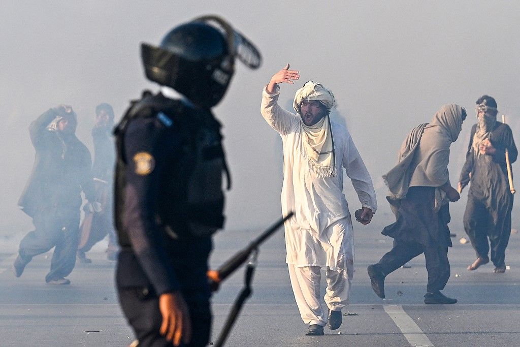 A supporter of Pakistan Tehreek-e-Insaf (PTI) party gestures after tear gas was fired by the police to disperse the crowd during a protest to demand the release of former prime minister Imran Khan in Islamabad on November 26, 2024. Thousands of protestors calling for the release of Pakistan's jailed ex-prime minister Imran Khan defied roadblocks and tear gas to march to the gates of the nation's capital on November 26. (Photo by Aamir QURESHI / AFP)