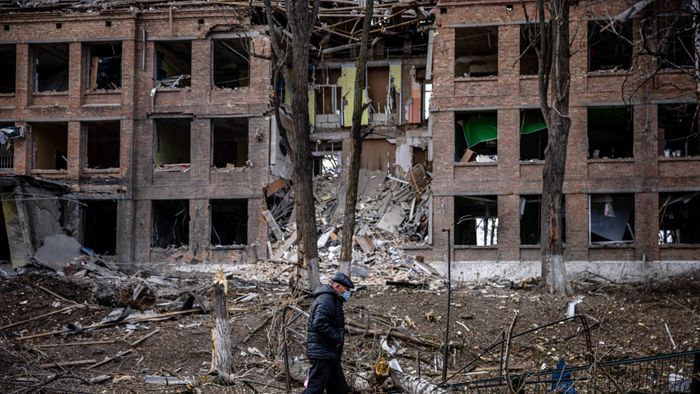 A man walks in front of a destroyed building after a Russian missile attack in the town of  Vasylkiv, near Kyiv, on February 27, 2022. Ukraine's foreign minister said on February 27, that Kyiv would not buckle at talks with Russia over its invasion, accusing President Vladimir Putin of seeking to increase "pressure" by ordering his nuclear forces on high alert. (Photo by Dimitar DILKOFF / AFP)