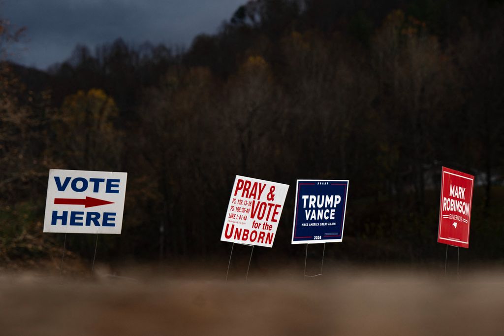 Signs are seen outside a temporary voting site located in a tent that is also sheltering volunteer police due to damages caused by Hurricane Helene, on Election Day, November 5, 2024, in Burnsville, North Carolina. (Photo by Allison Joyce / AFP)