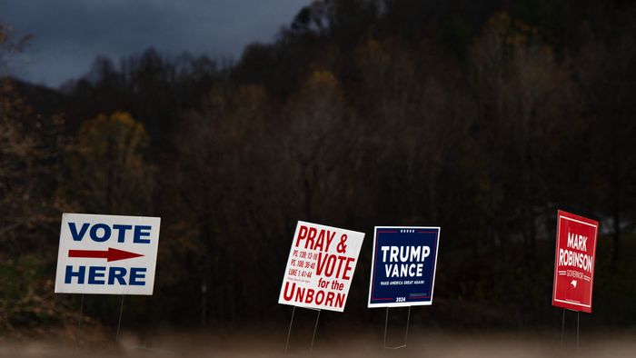 Signs are seen outside a temporary voting site located in a tent that is also sheltering volunteer police due to damages caused by Hurricane Helene, on Election Day, November 5, 2024, in Burnsville, North Carolina. (Photo by Allison Joyce / AFP)