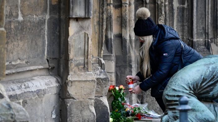 AFP or licensors/A mourner lights a candle near the Christmas market where a car crashed into a crowd killing at least two and injuring more than 60 people the evening before, on December 21, 2024 in Magdeburg, eastern Germany. At least two person was killed and 68 injured December 20, 2024 in a suspected attack on a Christmas market in the eastern Germany city of Magdeburg, local authorities said. (Photo by John MACDOUGALL / AFP)