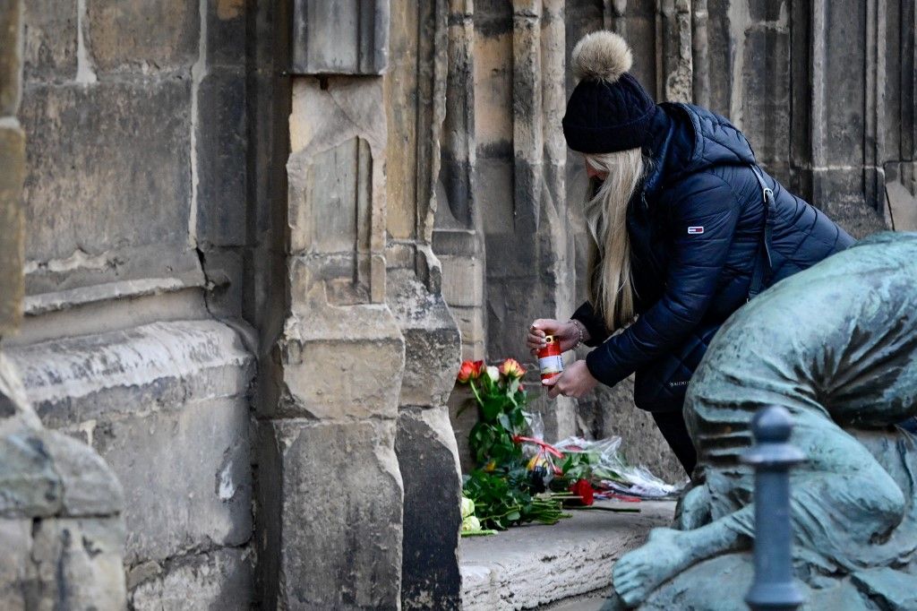 AFP or licensors/A mourner lights a candle near the Christmas market where a car crashed into a crowd killing at least two and injuring more than 60 people the evening before, on December 21, 2024 in Magdeburg, eastern Germany. At least two person was killed and 68 injured December 20, 2024 in a suspected attack on a Christmas market in the eastern Germany city of Magdeburg, local authorities said. (Photo by John MACDOUGALL / AFP)