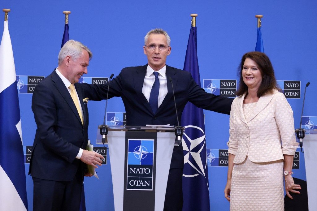 Jens Stoltenberg (C) NATO-főtitkár megöleli Pekka Haavisto finn külügyminisztert (L) és Ann Linde svéd külügyminisztert, miután Finnország és Svédország csatlakozási jegyzőkönyvét aláírták a NATO brüsszeli központjában 2022. július 5-én