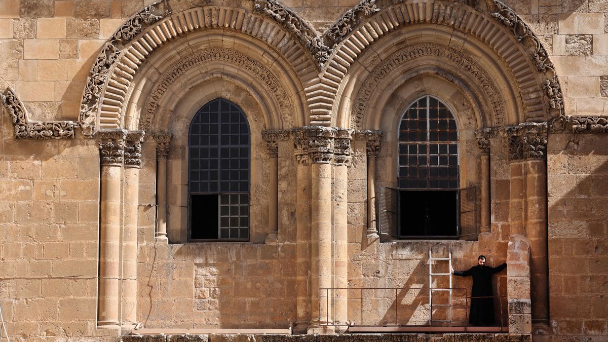 Lugas
An Armenian Apostolic priest guards the "Immovable Ladder" under one of the windows of the church of the Holy Sepulchre, while the Greek Orthodox celebrate a mass during Maundy Thursday (Holy Thursday) in Jerusalem, on April 29, 2021. The so-called immovable ladder was in place by 1728 and has remained there ever since the 1757 Status Quo was established, agreeing that no cleric of the six ecumenical Christian orders may move, rearrange, or alter any property without the consent of the other five orders. (Photo by Emmanuel DUNAND / AFP)