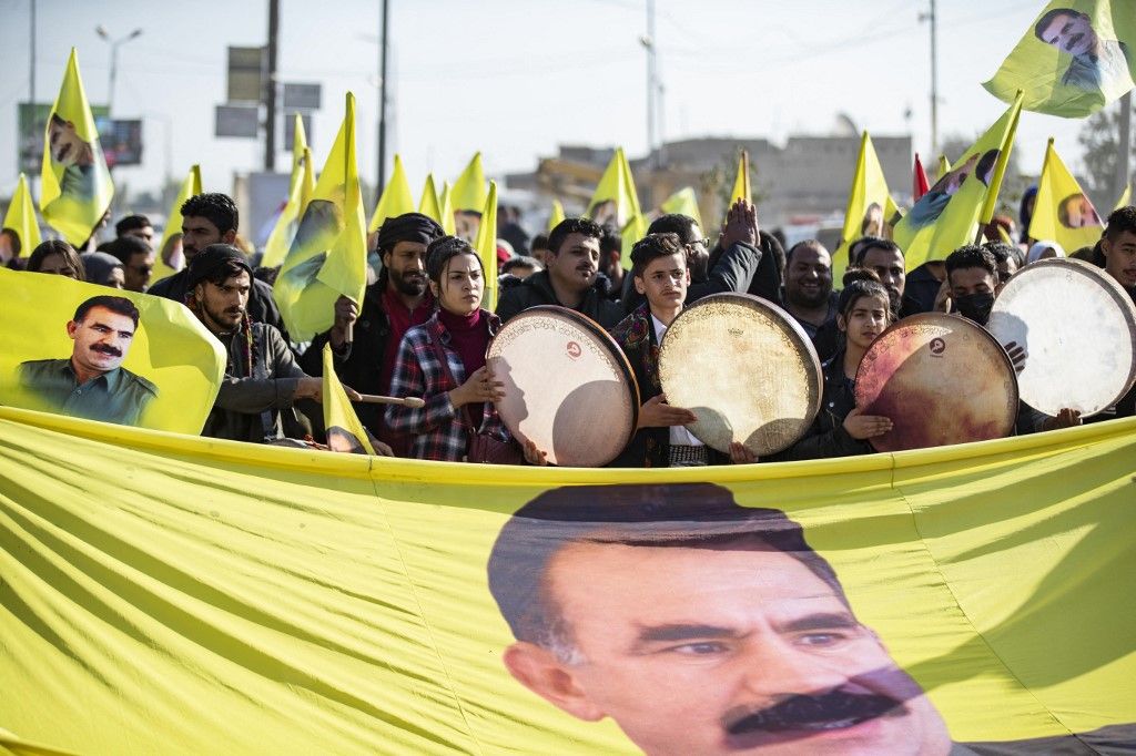 Tüntetők egy nagy transzparenssel vonulnak fel, amelyen Abdullah Öcalan, a Kurdisztáni Munkáspárt (PKK) vezetőjének az arca látható – aki jelenleg egy törökországi börtönben van