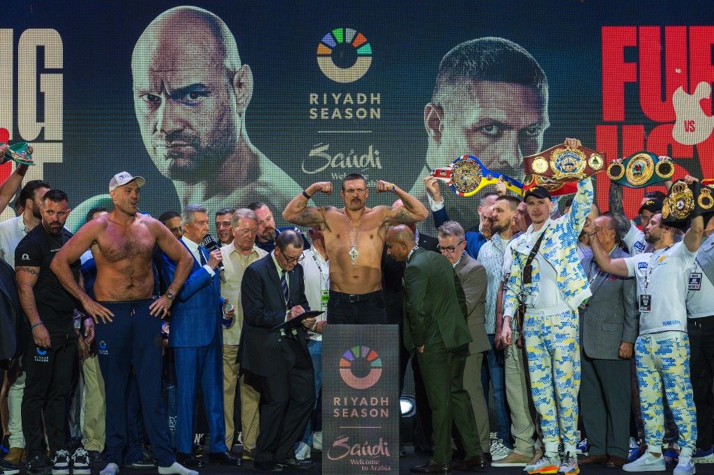 AFP or licensors/Britain's Tyson Fury (L) and Ukraine's Oleksandr Usyk (C) gesture on stage during the official weigh-in on the eve of their heavyweight world boxing championship fightin Riyadh on May 17, 2024. (Photo by Yasser al-UMARI / AFP)