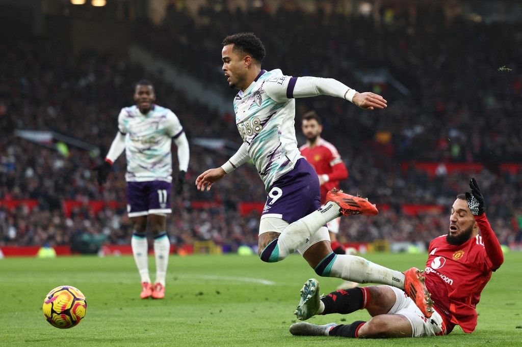 AFP or licensors/Manchester United's Moroccan defender #03 Noussair Mazraoui (R) fouls Bournemouth's Dutch striker #19 Justin Kluivert (C) for a penalty during the English Premier League football match between Manchester United and Bournemouth at Old Trafford in Manchester, north west England, on December 22, 2024. (Photo by Darren Staples / AFP) / RESTRICTED TO EDITORIAL USE. No use with unauthorized audio, video, data, fixture lists, club/league logos or 'live' services. Online in-match use limited to 120 images. An additional 40 images may be used in extra time. No video emulation. Social media in-match use limited to 120 images. An additional 40 images may be used in extra time. No use in betting publications, games or single club/league/player publications. / 