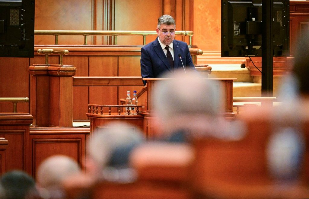 Románia miniszterelnöke, Marcel Ciolacu 2024. december 23-án a parlament előtt tartja beszédét (Fotó: AFP)