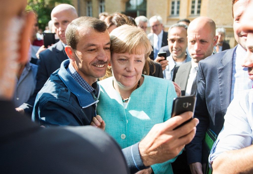 Migráns szelfit készít Angela Merkel akkori német kancellárral 2015. szeptember 10-én (Fotó: AFP)