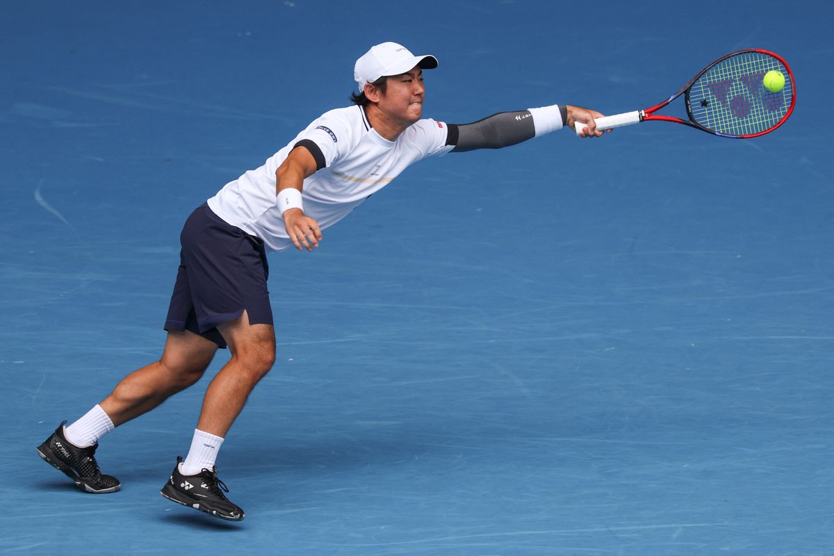 Japan's Yoshihito Nishioka hits a return against Spain's Carlos Alcaraz during their men's singles match on day four of the Australian Open tenisz tournament in Melbourne on January 15, 2025. (Photo by Adrian DENNIS / AFP) / -- IMAGE RESTRICTED TO EDITORIAL USE - STRICTLY NO COMMERCIAL USE --