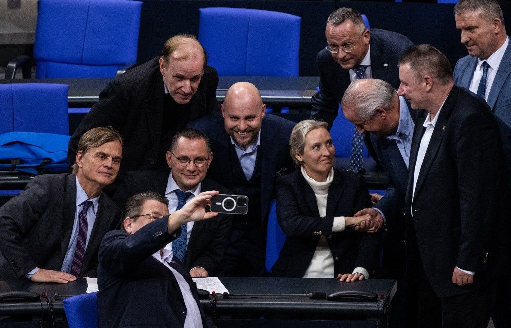 Az AfD társvezetői, Alice Weidel (3.R) és Tino Chrupalla (2.L.) fotózkodva ünnepelnek a Bundestagban  az elfogadott indítvány után 2025. január 29-én Berlinben