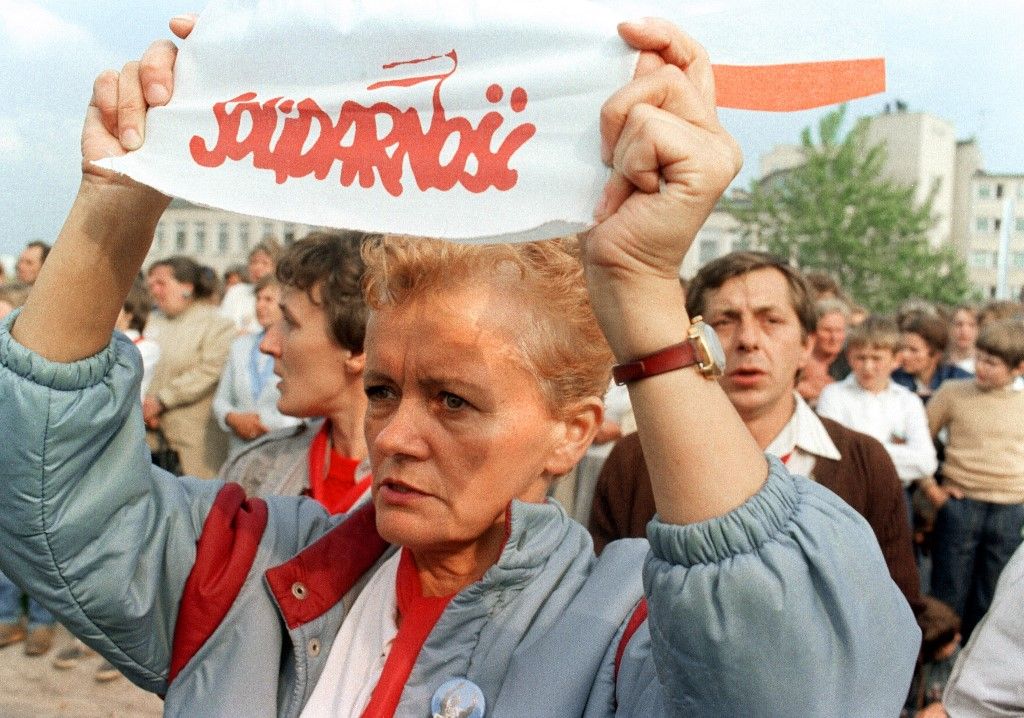 Egy lengyel nő egy Szolidaritás feliratú transzparenst tart, amint ő és több ezer hívő összegyűlik II. János Pál pápa szentmiséjén Gdanskban 1987-ben