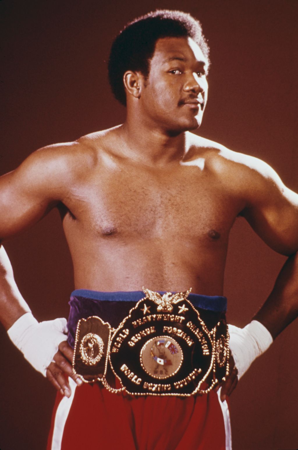 Heavyweight boxing champion George Foreman shows off his championship belt during a training session (ahead of his title fight with Muhammad Ali), October 1974. (Photo by UPI/Bettmann Archive/Getty Images)