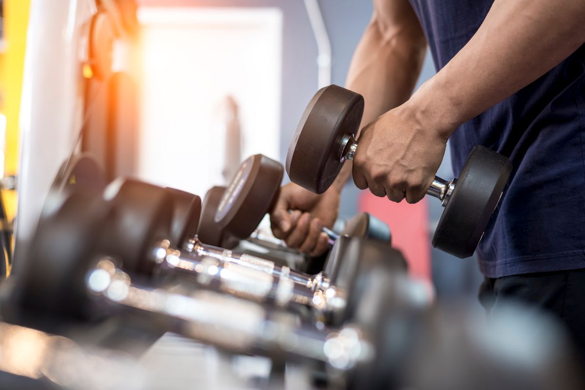 Handsome man exercise with dumbbell in the gym