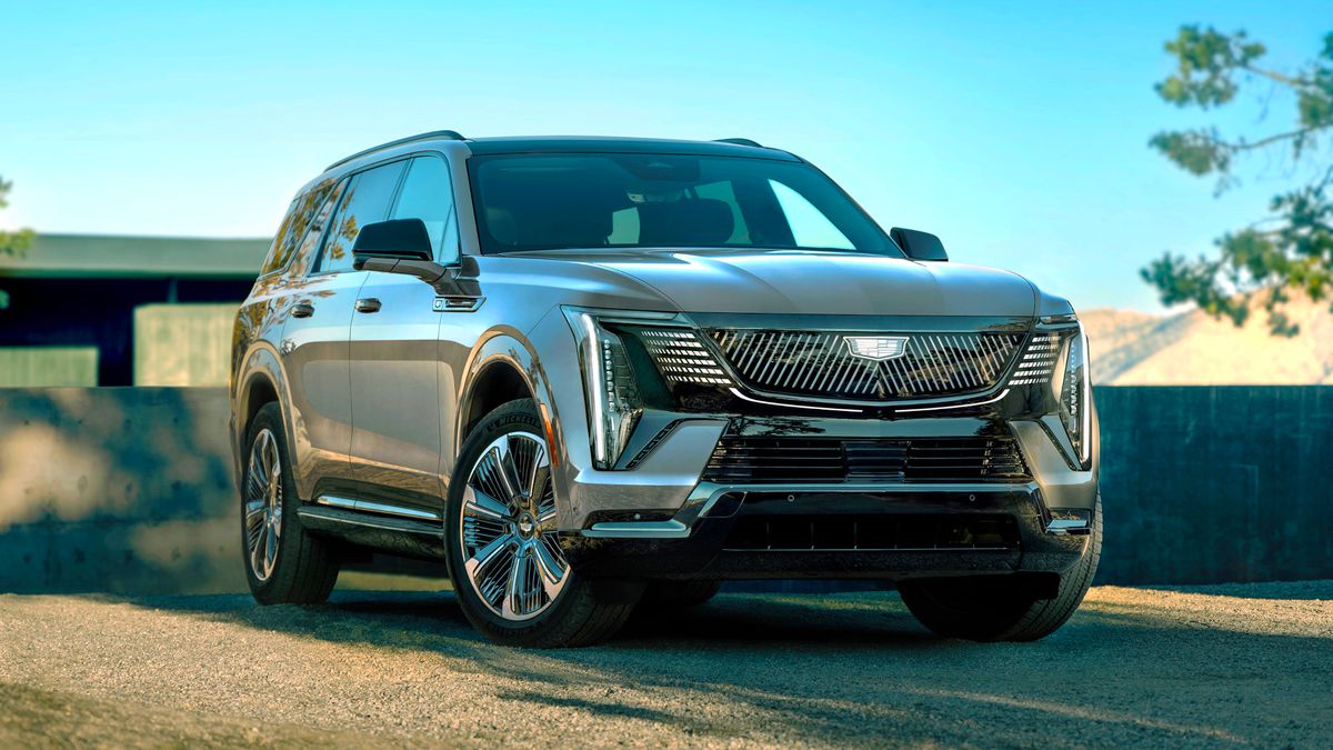 Front 3/4 view of the Cadillac ESCALADE IQL in Barb Wire exterior color, showcasing Crystal Shield grille.