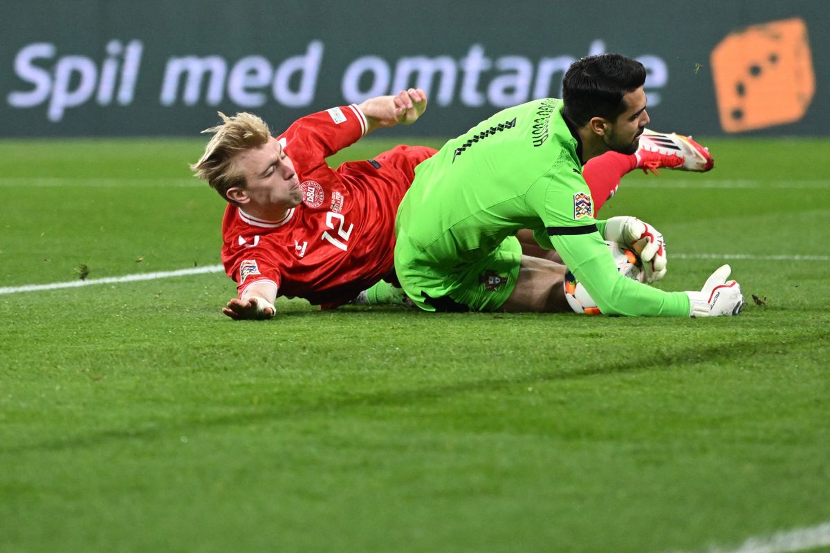 Denmark's forward #12 Mika Biereth (L) and Portugal's goalkeeper 01 Diogo Costa vie for the ball during the UEFA Nations League quarter-final, first-leg football match Denmark v Portugal at the Parken Stadium in Copenhagen on March 20, 2025. (Photo by Jonathan NACKSTRAND / AFP)