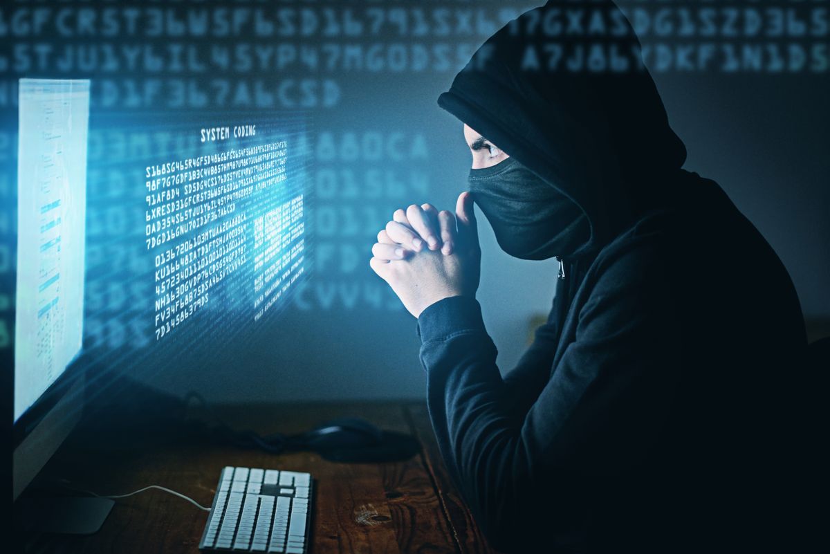 Cybercrime, hacker and thinking at computer for virus, overlay and futuristic at desk. Male criminal, hoodie and ready for coding, cyber attack and programming for malware with tech, scam and data
