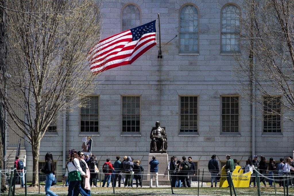 Tüntetők táblákkal állnak a John Harvard-szobor körül (Fotó: AFP)