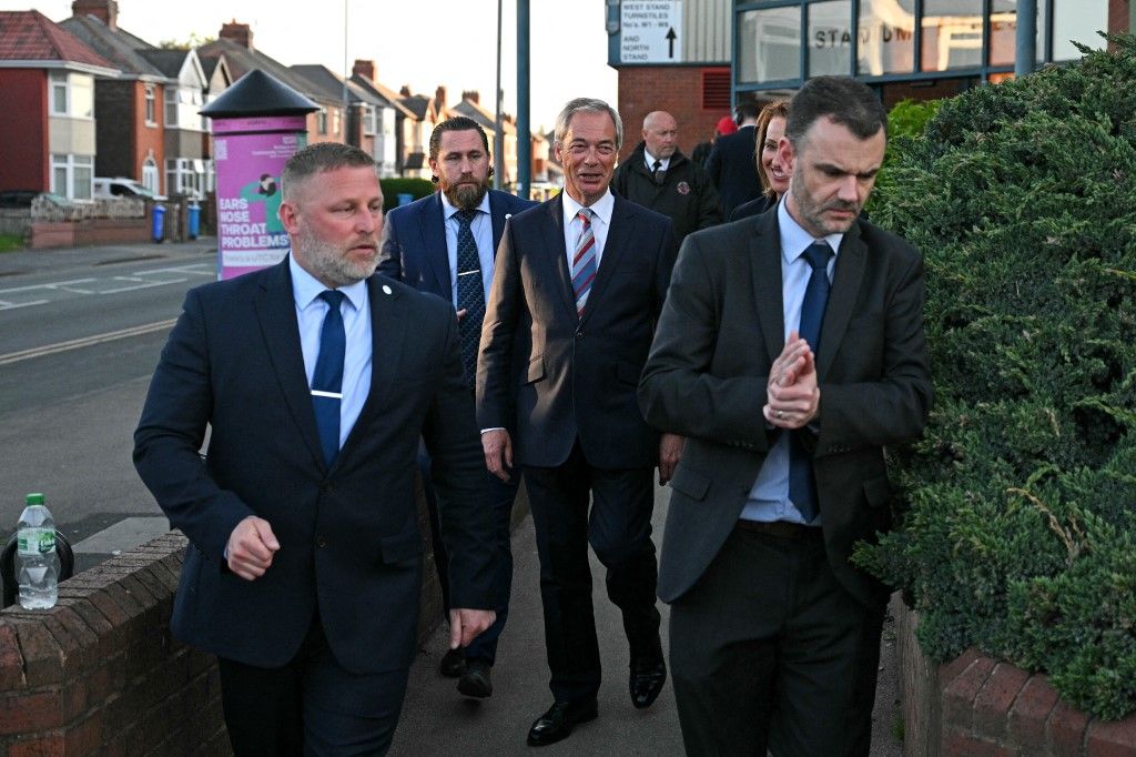 Nigel Farage (C), leader of the Reform UK party, leaves after the victory of Sarah Pochin, the partys candidate, in the Runcorn & Helsby by-election at the DCBL Stadium in Widnes, north-west England, in the early hours of May 2, 2025. Britain's hard-right Reform UK party, led by anti-immigrant firebrand Nigel Farage, snatched a parliamentary seat from the ruling Labour party on on May 2, 2025 in a blow to Prime Minister Keir Starmer. The Runcorn by-election is made difficult by the vote being sparked by Labour MP Mike Amesbury quitting after receiving a suspended jail sentence for punching a man. Labour won the constituency with a 53-percent vote share last year, while Reform got just 18 percent, but Britain's Prime Minister Keir Starmer has acknowledged it will be "tough" to win. (Photo by Oli SCARFF / AFP)