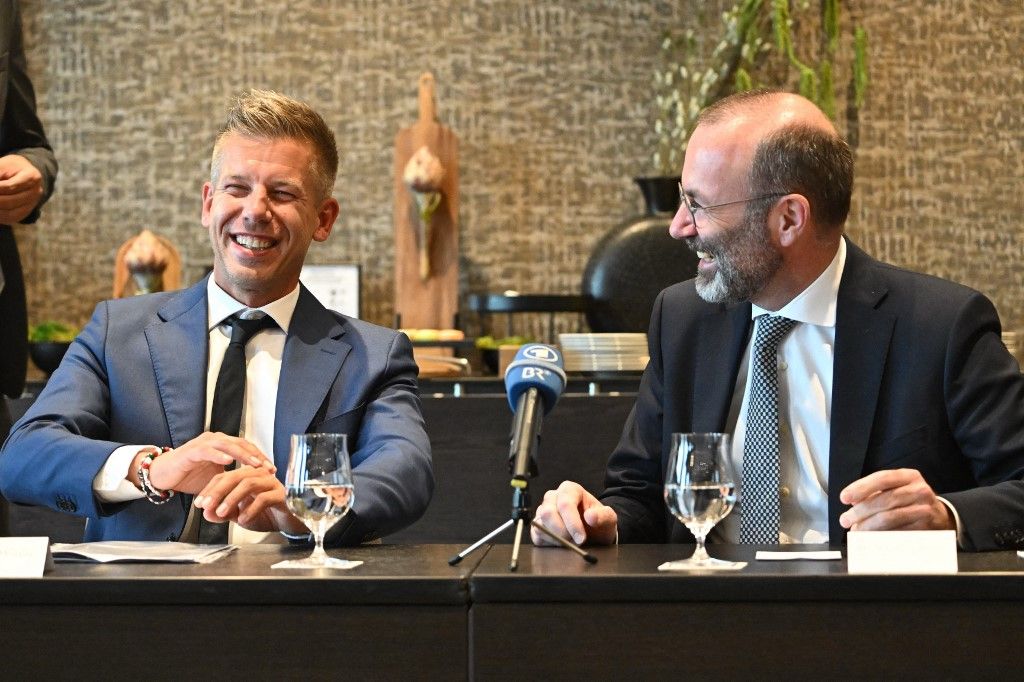 Leader of Hungarian Tisza party and former government member turned opposition leader Peter Magyar (L) and President of the centre-right European People's Party (EPP) Manfred Weber react during a meeting with local press in a Budapest's hotel Hungary on June 14, 2024. Weber arrived to Budapest about the accession of the seven elected members of the European Parliament of the Tisza party. (Photo by Attila KISBENEDEK / AFP)