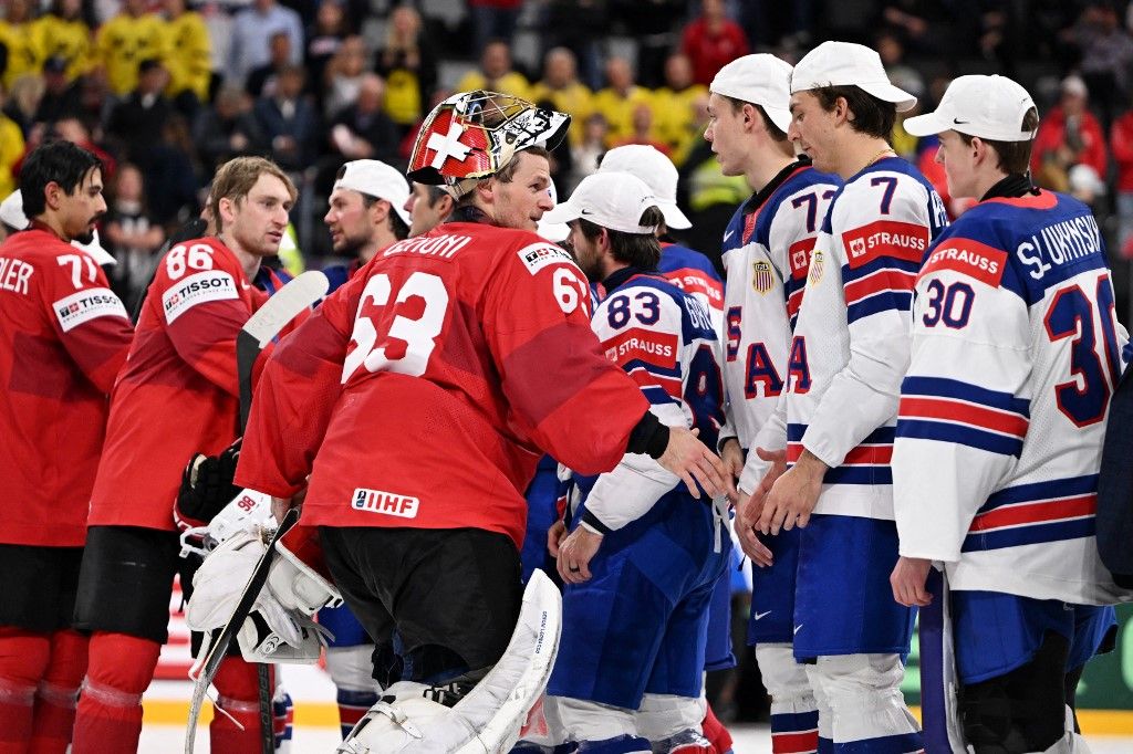 Jégkorongban így dukál: a vesztes fél, ezúttal Svájc játékosai gratulálnak a győztes USA hokisanak a döntő után
