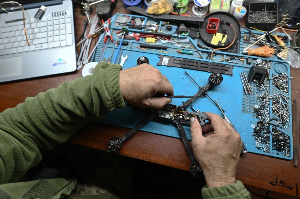 A Ukrainian serviceman of the 30th separate mechanized brigade prepares an FPV (First-Person View) drone in a workshop in Donetsk region on October 22, 2024, amid the Russian invasion of Ukraine. (Photo by Genya SAVILOV / AFP)