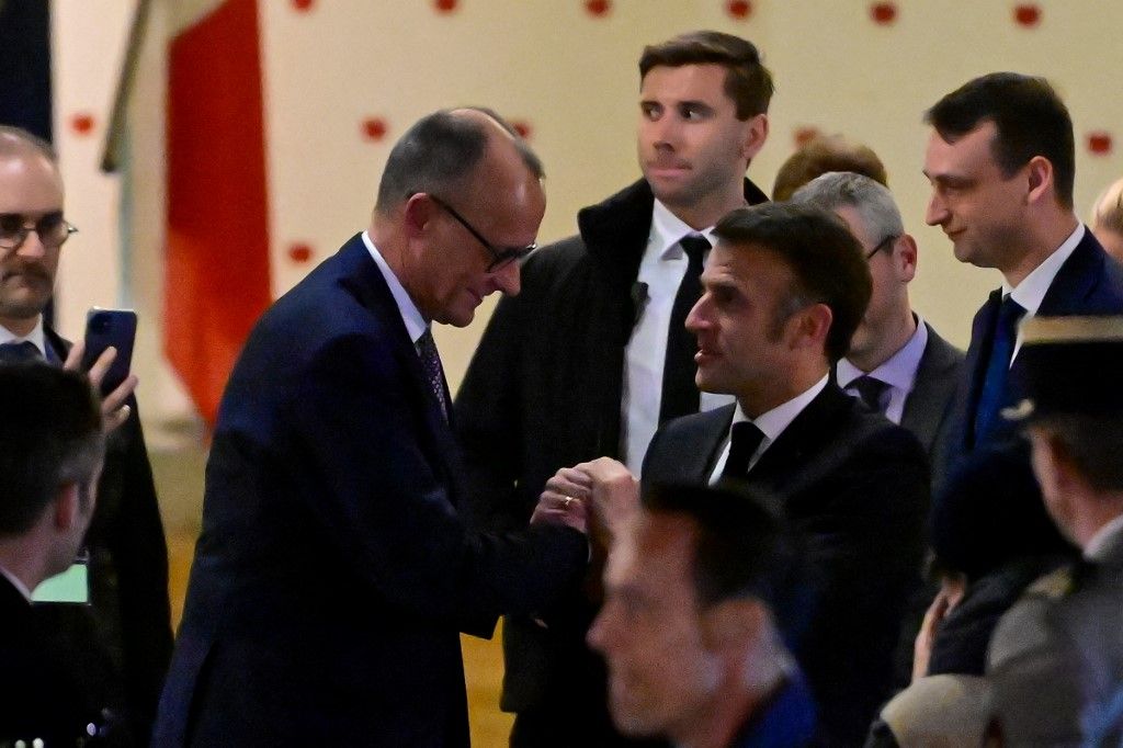 French President Emmanuel Macron and Friedrich Merz (L), leader of Germany's conservative Christian Democratic Union (CDU) party say their goodbyes after having dinner together in the French Embassy in Berlin on March 18, 2025. (Photo by John MACDOUGALL / AFP)