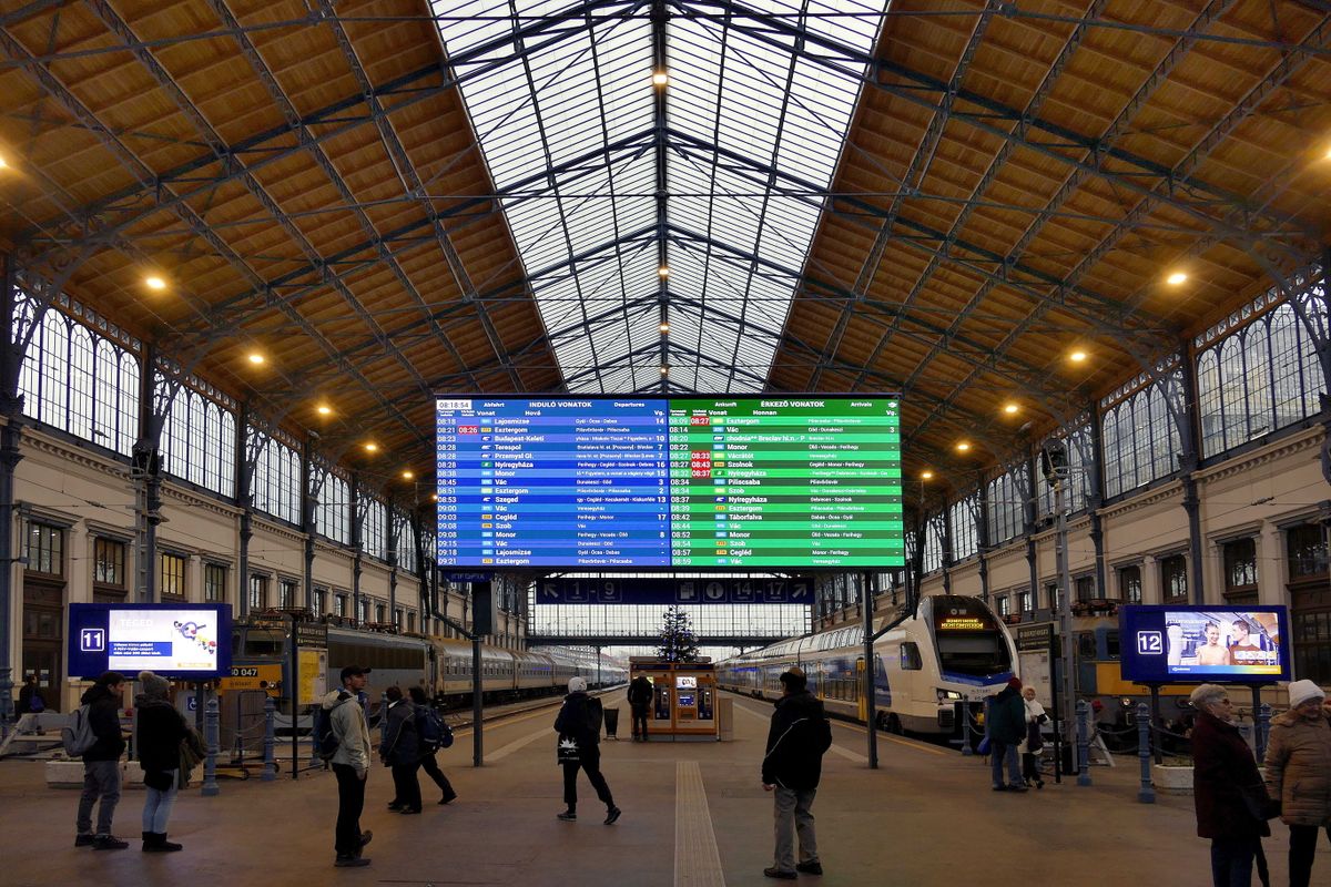 Budapest, 2022. december 7.Érdeklődők nézik a számítógéppel vezérelt utastájékoztató elektronikus kijelzőtáblát a főváros Nyugati pályaudvarának nemrég felújított csarnoképületében. A fejpályaudvar kőépületi terveit az osztrák August W. De Serres építész, az acélszerkezetét pedig Seyrig Theofil, a párizsi Eiffel-toronyról világhírűvé vált Eiffel-cég munkatársa tervezte, a 19. század végén. Az épület az utazóközönség előtt 1877 őszén nyílt meg. Balra a MÁV Start Zrt. egyik Záhony felől nemrég érkezett gyorsvonati szerelvénye, jobbra pedig, egy zónázó járatként közlekedő Stadler KISS emeletes vonat vár menetrend szerinti indulásra.MTVA/Bizományosi: Jászai Csaba ***************************Kedves Felhasználó!Ez a fotó nem a Duna Médiaszolgáltató Zrt./MTI által készített és kiadott fényképfelvétel, így harmadik személy által támasztott bárminemű – különösen szerzői jogi, szomszédos jogi és személyiségi jogi – igényért a fotó szerzője/jogutódja közvetlenül maga áll helyt, az MTVA felelőssége e körben kizárt. késési biztosítás