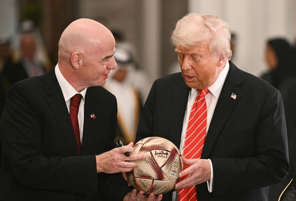 FIFA president Gianni Infantino gives US President Donald Trump a soccer ball to autograph during a signing ceremony after a state dinner with Qatar's Emir Sheikh Tamim bin Hamad al-Thani at the Lusail Palace in Doha on May 14, 2025. (Photo by Brendan SMIALOWSKI / AFP) / ALTERNATE CROP