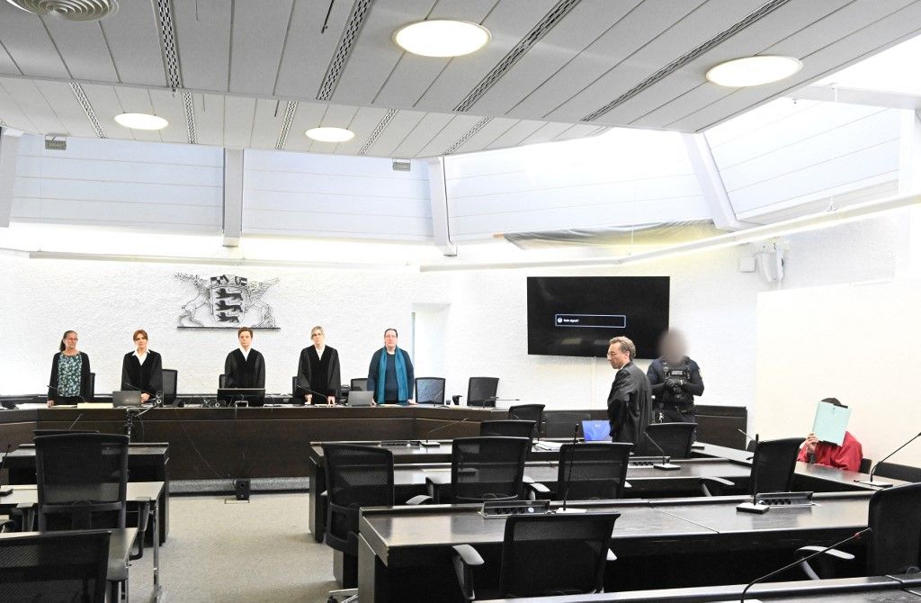 14 May 2025, Baden-Württemberg, Stuttgart: A defendant (r) sits in the courtroom with a file cover in front of his face before the start of his trial for murder. On the left, the judges with presiding judge Monika Lamberti (M). After a fatal knife attack on a jogger in Hochdorf (Esslingen district), a court wants to find out whether the alleged perpetrator actually stabbed out of pure frustration or whether there is another motive. The then 24-year-old refugee from Afghanistan attacked and killed the 56-year-old last November, according to the public prosecutor's office. Photo: Bernd Weißbrod/dpa - ATTENTION: Judicial officer and defendant(s) have been pixelated for legal reasons (Photo by BERND WEISSBROD / DPA / dpa Picture-Alliance via AFP)