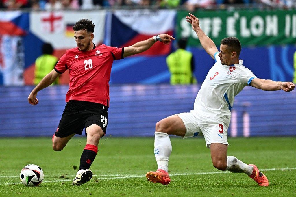 Georgia's midfielder #20 Anzor Mekvabishvili (L) shoots the ball next to Czech Republic's midfielder #03 Tomas Holes (R) during the UEFA Euro 2024 Group F football match between Georgia and the Czech Republic at the Volksparkstadion in Hamburg on June 22, 2024. (Photo by GABRIEL BOUYS / AFP)