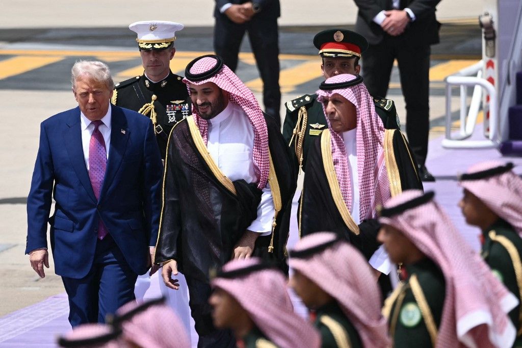 Saudi Crown Prince Mohammed bin Salman (C) walks with US President Donald Trump (L) upon his arrival in Riyadh on May 13, 2025. (Photo by Brendan SMIALOWSKI / AFP)