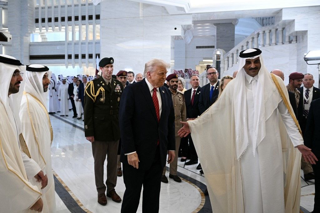Qatar's Emir Sheikh Tamim bin Hamad al-Thani (R) receives US President Donald Trump in the Qatari capital Doha on May 14, 2025. Trump touched down at Hamad International Airport in Doha, with relations between the two governments in the spotlight over Qatar's offer to Trump of a $400 million luxury aircraft to serve as a new Air Force One and then pass into his personal use. (Photo by Brendan SMIALOWSKI / AFP)