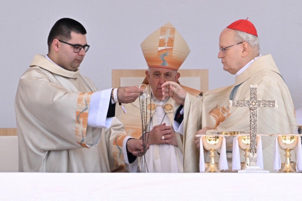 Pope Francis (C) and Cardinal Peter Erdo (R), Archbishop of Esztergom-Budapest and Primate of Hungary, celebrate a holy mass at Kossuth Lajos' Square during the Pope's visit in Budapest on April 30, 2023, the last day of his tree-day trip to Hungary. (Photo by Attila KISBENEDEK / AFP)