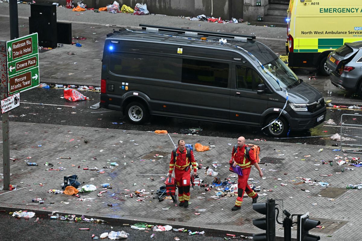 Members of the emergency services are pictured on the scene of an incident in Water Street, on the sidelines of an open-top bus victory parade for Liverpool's Premier League title win, in Liverpool, north-west England on May 26, 2025. A car collided with a number of pedestrians in Liverpool, northern England, on May 26 evening during Liverpool FC's Premier League victory parade, police said. Police said they were contacted shortly after 6pm (1700 GMT) following reports of a collision between a car and a number of pedestrians in the city centre. One man has been arrested, according to the police, who did not say whether there were any casualties. (Photo by Paul ELLIS / AFP)