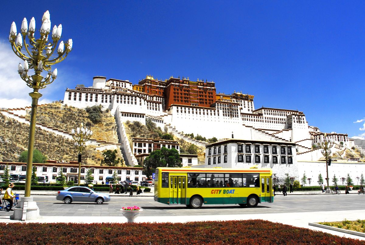 Tibet ősi népe és kultúrája még sok titkot rejt. Lhászai utcakép, a háttérben a híres Potala palotával, a mindenkori dalai láma rezidenciájával