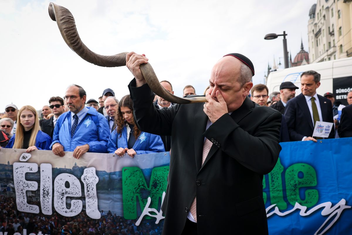 Verő Tamás főrabbi a sófár megfújásával indítja el az Élet menetét a budapesti Cipők a Duna-parton holokauszt-emlékműnél 2025. május 11-én (Fotó: MTI/Hegedüs Róbert)