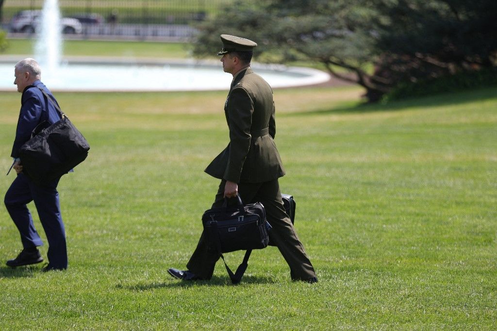 A military aide to U.S. President Donald Trump carries the nuclear football to Marine One on the South Lawn of the White House in Washington, D.C. on April 29, 2025. Trump is heading to Warren, MI to deliver his '100th Day in Office Achievement Speech'. (Photo by Bryan Dozier/NurPhoto) (Photo by Bryan Dozier / NurPhoto via AFP)