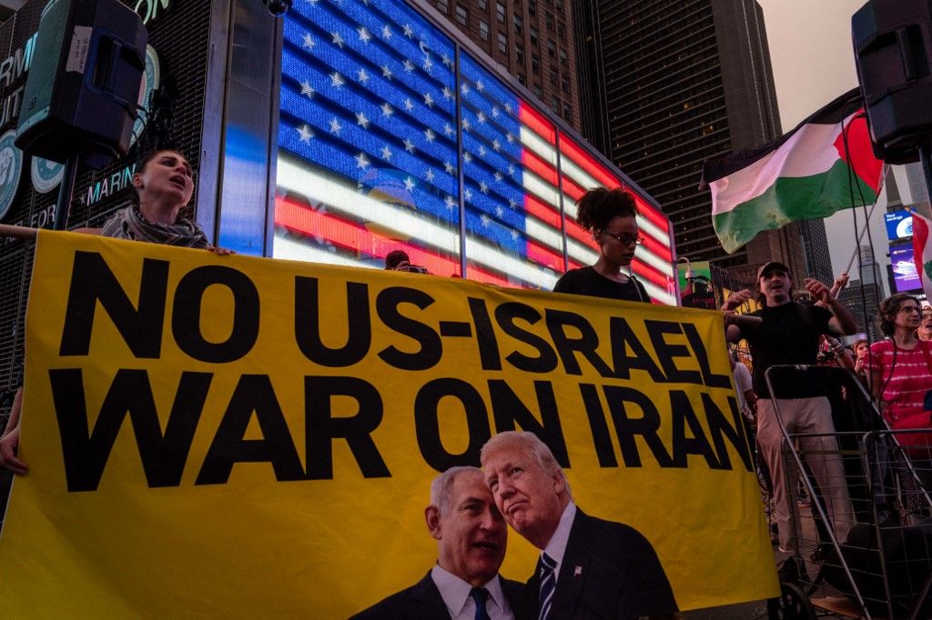 NEW YORK, NEW YORK - JUNE 18: People rally in Times Square calling for the Trump administration not to go to war with Iran, on June 18, 2025 in New York City. President Donald Trump said Wednesday he had not yet decided whether the U.S. military would take part in Israel's ongoing strikes on Iran.   Adam Gray/Getty Images/AFP (Photo by Adam Gray / GETTY IMAGES NORTH AMERICA / Getty Images via AFP)